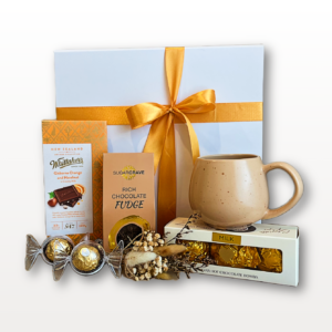 Chocolate gift box NZ with premium chocolate fudge, dark chocolate pudding, hot chocolate bombs, shortbread fingers, mug, and golden spoons